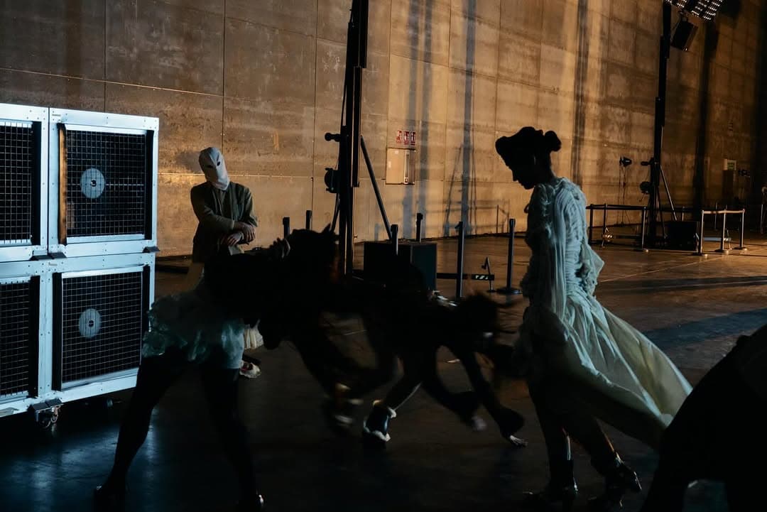 Figures moving through a dim room